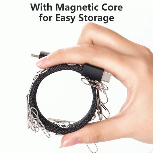 A-hand-holding-a-coiled-black-braided-USB-cable-with-a-magnetic-core-demonstrating-its-flexible-and-easy-to-store-design